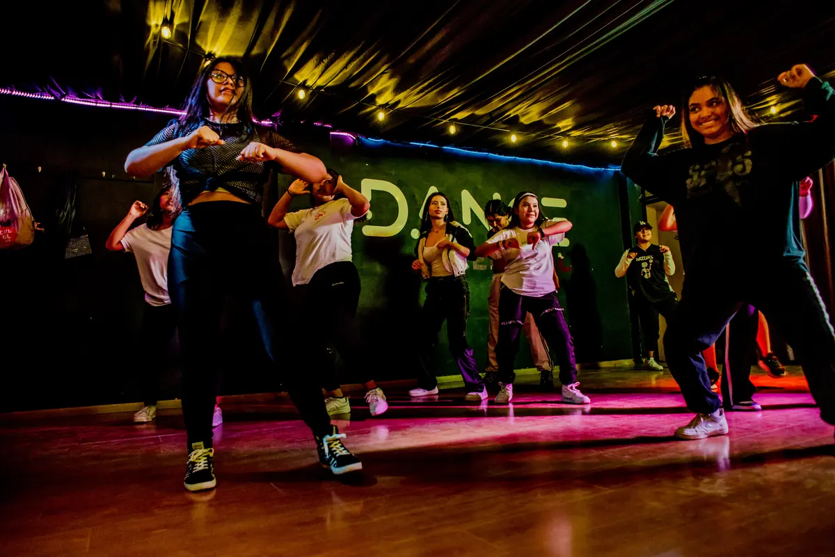 Alumnos de hip hop marcando un paso al frente del grupo durante la clase