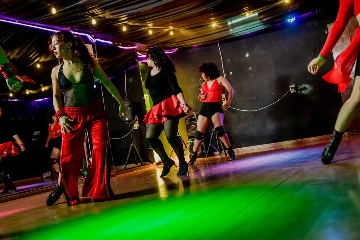 Alumnas de reggaetón de Dance Central bajo las luces de colores del salón