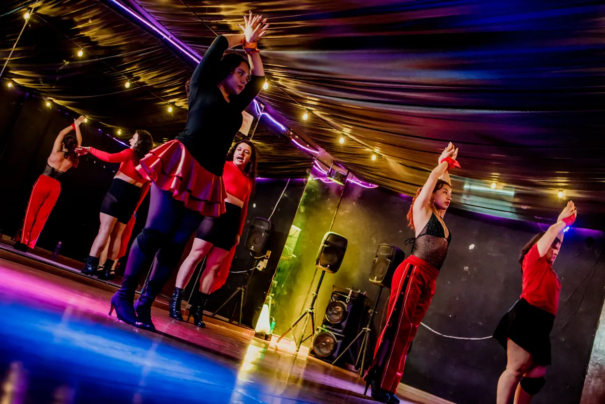 Grupo de reggaetón marcando una coreografía con iluminación de escenario